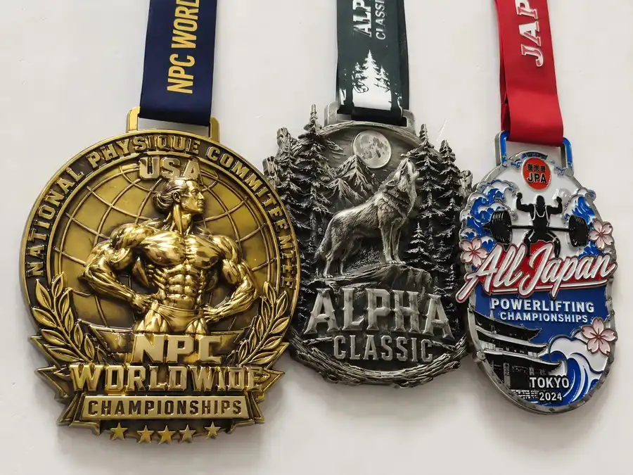 Three oversized custom medals with bodybuilding, wildlife and powerlifting designs shown side by side