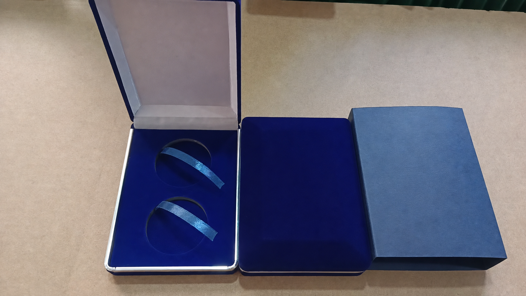 Anonymized navy velvet coin presentation boxes with fitted inserts